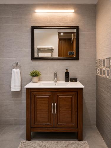 a bathroom with a sink and a mirror at Lawrence View Hotel, Lahore in Lahore