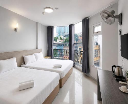 a hotel room with two beds and a balcony at Sleep & Go Capsule Hostel Bui Vien District 1 in Ho Chi Minh City