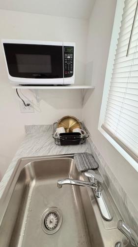 a kitchen counter with a sink and a microwave at HollywoodCozyStudio in Hollywood