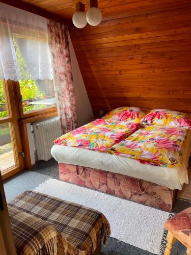 a small bedroom with a bed and a window at Chata na Polane in Vyšné Hágy