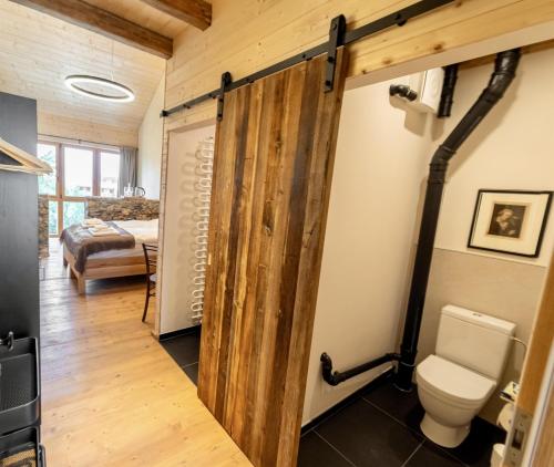 a bathroom with a wooden door and a toilet at Eidenberger's Herberge in Eidenberg
