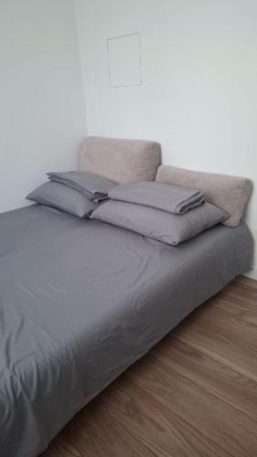 a bed with three pillows on top of it at Apartment Tarasy centrum in Siemiatycze