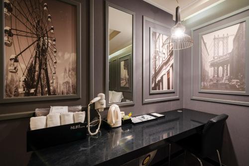 a hotel room with a phone and pictures on the wall at Busan Gwangalli Nuri Hotel in Busan