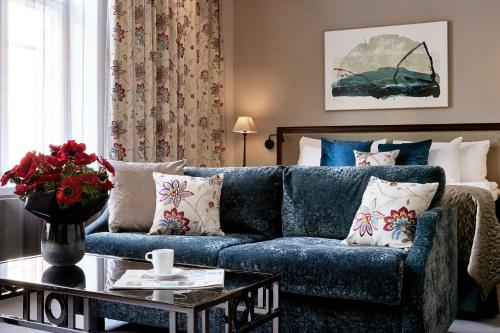 a living room with a blue couch and a table at Hotel Haven in Helsinki