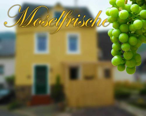 a bunch of green grapes in front of a yellow house at Moselfrische in Zell an der Mosel