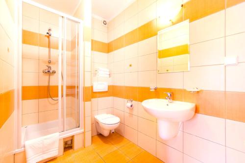a bathroom with a toilet and a sink and a shower at Astra Dziwnówek Dom Gościnny in Dziwnówek