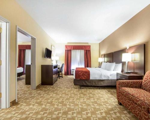 a hotel room with a bed and a chair at Comfort Suites in Rome