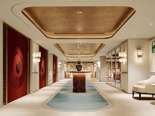 a hallway of a hotel lobby with a table on a rug at The St. Regis Jakarta in Jakarta