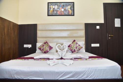 a bed with two white towels and a bow at Hotel 4G in Bhopal