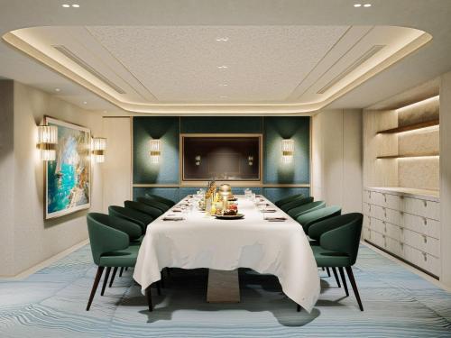 a dining room with a table and green chairs at The St. Regis Jakarta in Jakarta