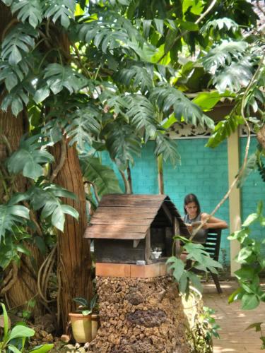 a woman sitting in a chair next to a bird house at SURF N SUN - Arugam Bay in Arugam Bay