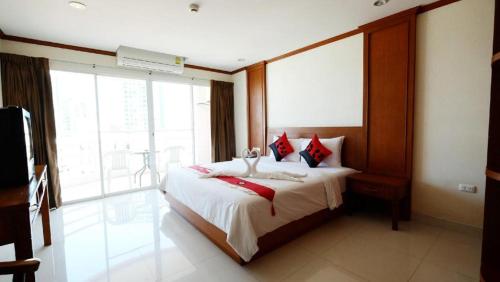 a bedroom with a bed and a large window at Phu View Talay Resort in Pattaya South