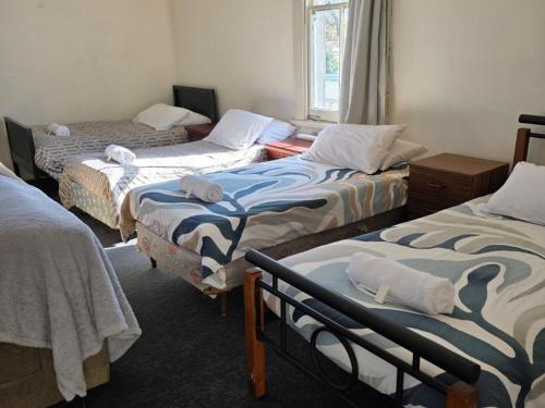 a room with three beds in a room at Courthouse Hotel Gunnedah in Gunnedah
