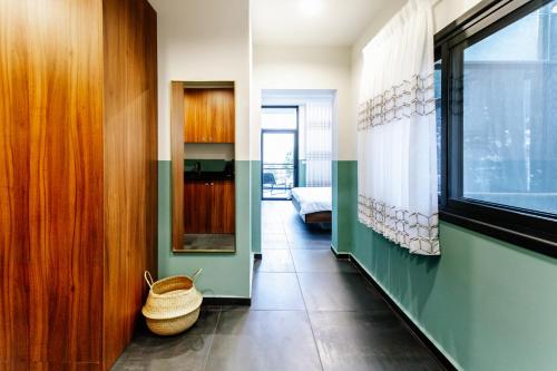 a room with a hallway with a basket on the floor at Domus Carmel Hotel in Haifa