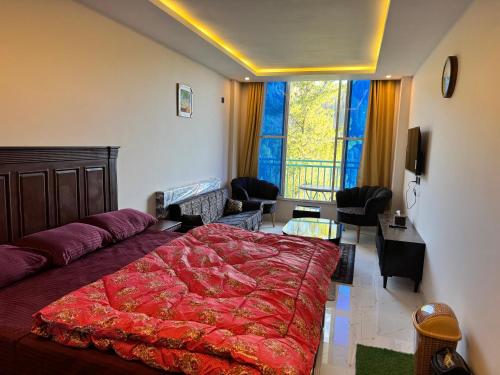 a bedroom with a large bed and a living room at Swiss Suits, Suit 407 in Taiwāl
