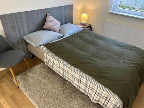 a bed with two pillows and a chair in a room at FLC Rooms in Rødby