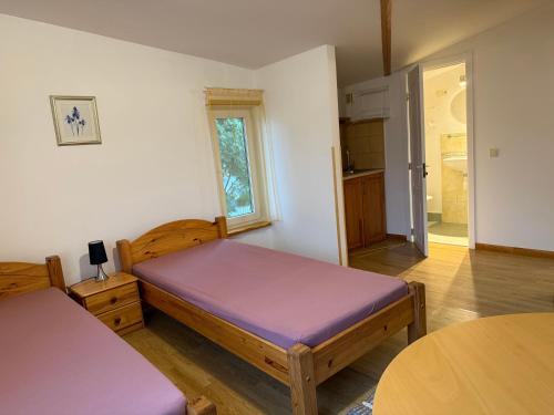a bedroom with two beds and a table in it at Guest House Maija in Ventspils