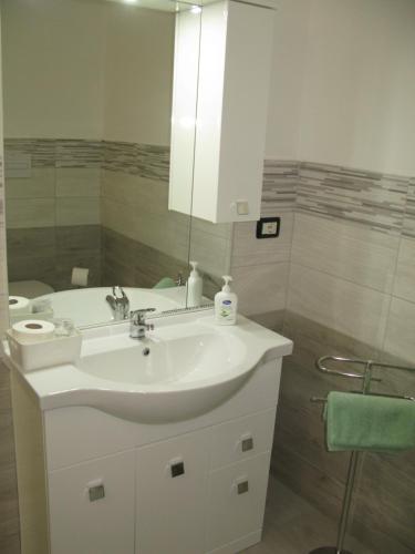 a bathroom with a white sink and a mirror at Camera gigli al civico 29 in Collestrada