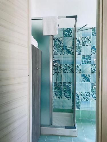 a bathroom with a shower with blue and white tiles at Casa Vacanza Finalmente in SantʼAngelo le Fratte