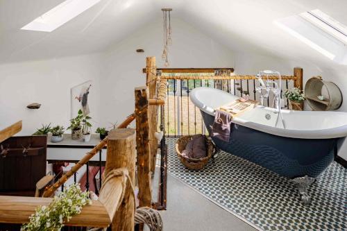 a bathroom with a large blue tub in a room at Rosie's Barn in Penrith