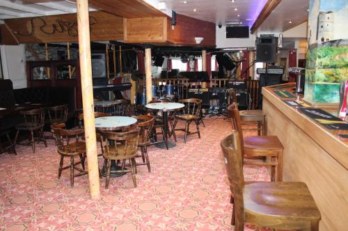 a bar with tables and chairs in a restaurant at Middlegate Hotel in Pembroke