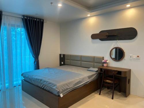a bedroom with a bed and a desk and a mirror at Tâm An Luxury Hotel in Ninh Lão