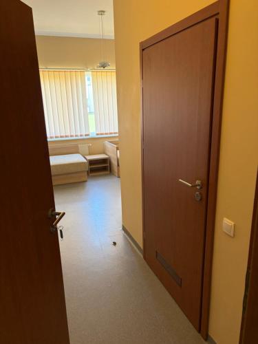 a hallway with a door and a room with a couch at Kambarių nuoma in Utena