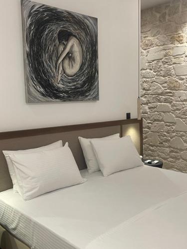 ein Bett in einem Schlafzimmer mit einem Gemälde an der Wand in der Unterkunft Villa Yi in Chorafakia