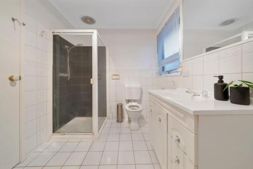 a white bathroom with a shower and a toilet at Relax and Rejuvenate in Vermont