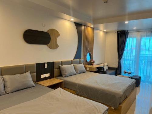 a hotel room with two beds and a window at Tâm An Luxury Hotel in Ninh Lão