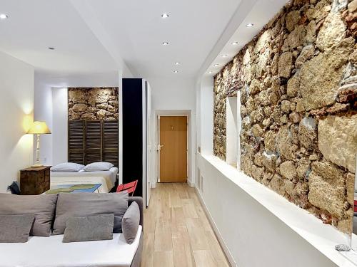 a room with two beds and a stone wall at COCON HYPER CENTRE-VILLE TOUT CONFORT (8) in Ajaccio