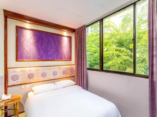 a bedroom with a bed and a window at Hotel 165 in Singapore