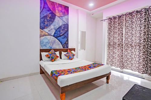 a bedroom with a bed and a painting on the wall at FabHotel Saptshrungi in Nashik