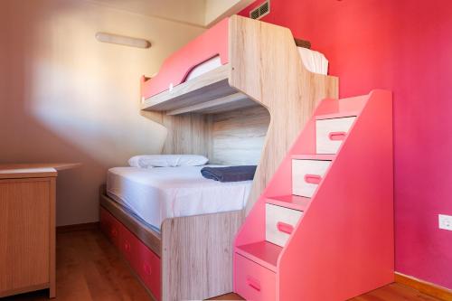 a bunk bed in a room with a pink wall at Beachfront chalet in Valencia in Valencia