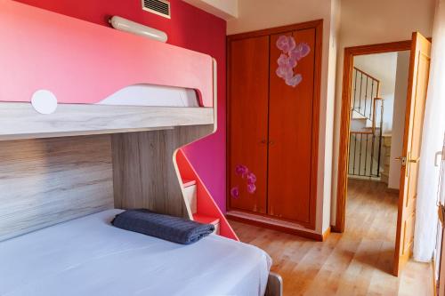 a bedroom with a bunk bed with a pink wall at Beachfront chalet in Valencia in Valencia