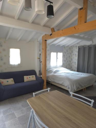 a bedroom with a bed and a couch in a room at Le chalet de la tranquillité ! in Parignargues