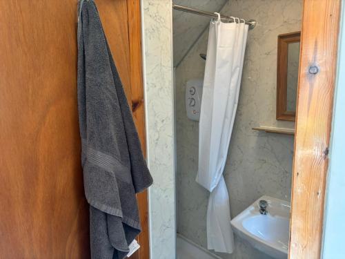a bathroom with a sink and a towel hanging on a wall at Barfad Self Catering Holiday Cottages in Tarbert