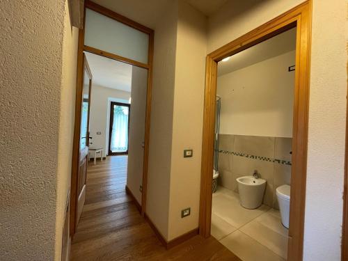 an empty bathroom with a toilet and a doorway at Alpèa in Lavarone
