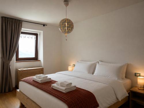 a bedroom with a large bed with towels on it at Alpèa in Lavarone