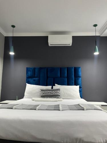 a large bed with a blue headboard in a bedroom at Lukholo guest house siyabuswa in Siyabuswa