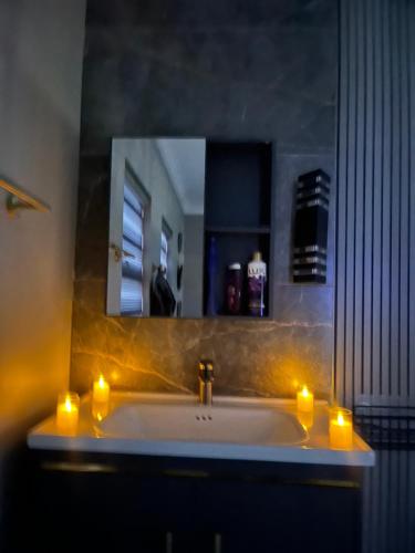 a bathroom with a sink with candles and a mirror at Lukholo guest house siyabuswa in Siyabuswa