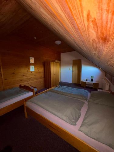 a bedroom with two beds in a wooden cabin at Hostinec U Havlů in Olomouc