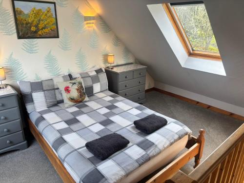 a bedroom with a checkered bed with two pillows at Barfad Self Catering Holiday Cottages in Tarbert