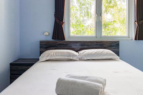 a bedroom with a large bed with a window at Dprof Exclusive Guesthouse Semarang RedPartner in Jatingaleh