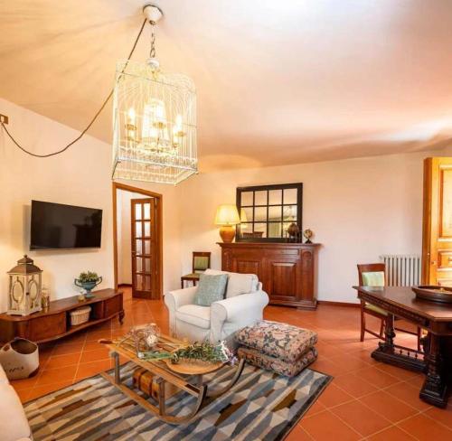 a living room with a white couch and a chandelier at Apartment Olearum in Panzano