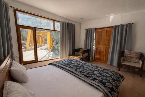 a bedroom with a bed and a large window at Namami Harsil in Harsil