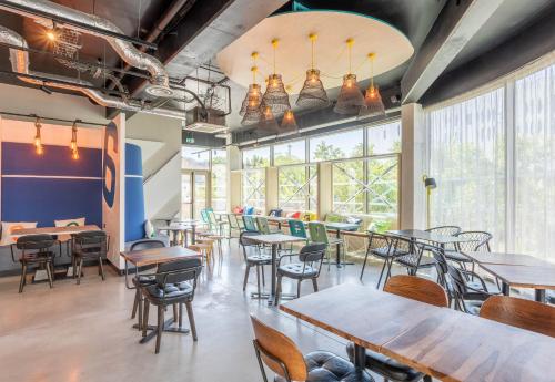 a restaurant with tables and chairs and large windows at B&B HOME La Ciotat in La Ciotat