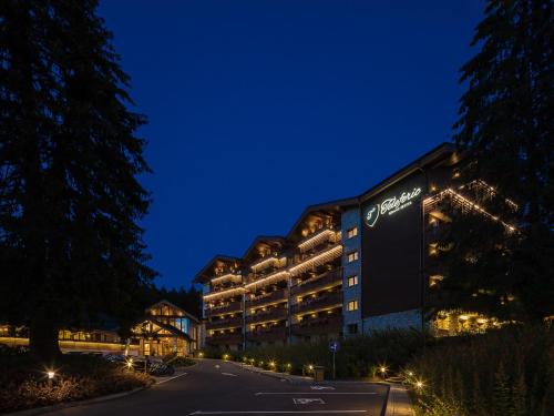 a building with a sign on the side of it at night at Teleferic Grand Hotel in Poiana Brasov