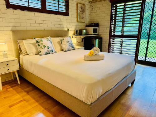 a bedroom with a large bed with a teddy bear on it at Garden Studio - Tranquil Forest Retreat in Currumbin Valley