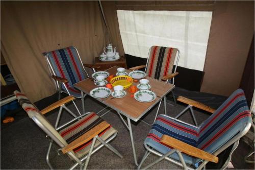 a table with two chairs and a tea set on it at KULT TRABANT "Villa Sachsenruh" direkt am Strand in Dranske
